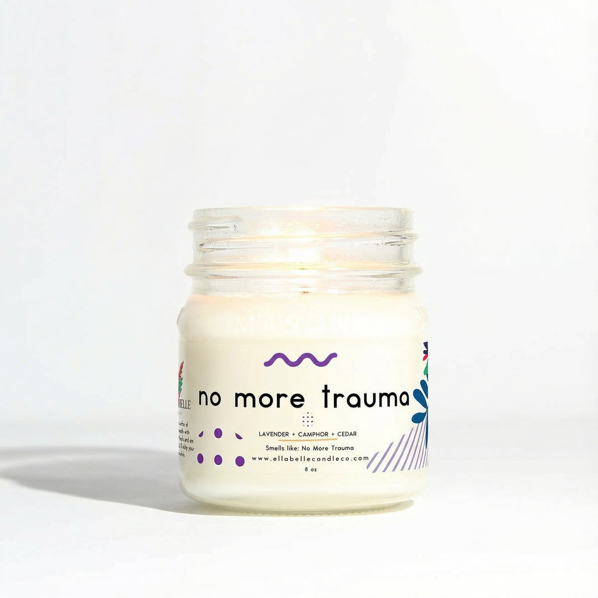 Candle jar labeled 'no more trauma' on a white background