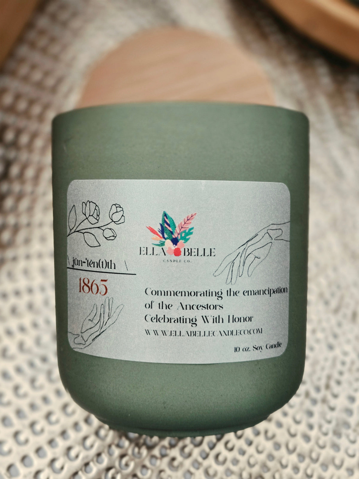 Green candle jar with a label on a textured surface