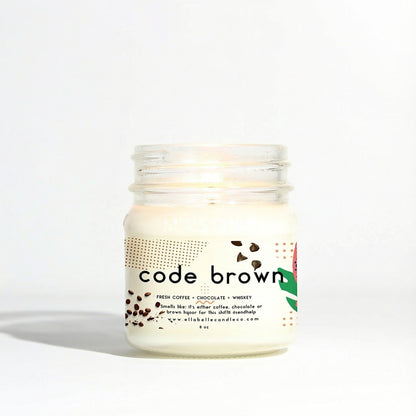Mason jar candle labeled 'code brown' with decorative elements on a clear background