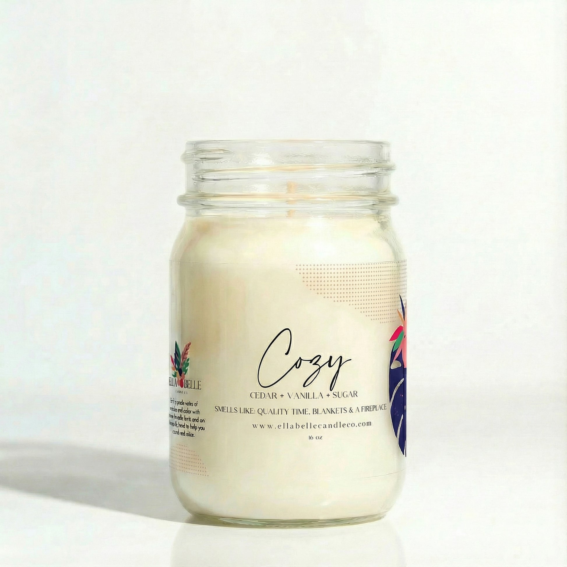 Candle jar labeled 'Cozy' with a minimal design on a clear background