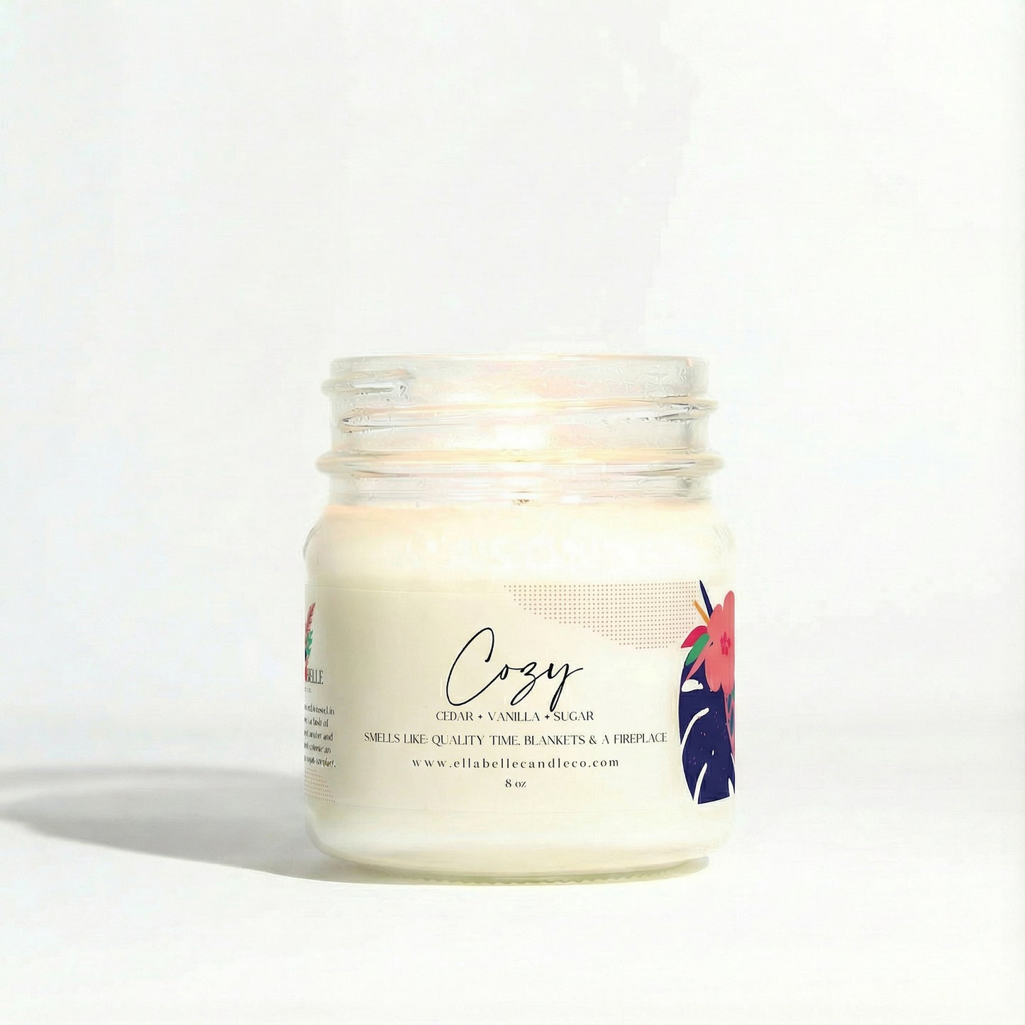 Candle jar labeled 'Cozy' with a minimal design on a clear background