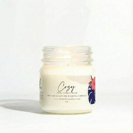 Candle jar labeled 'Cozy' with a minimal design on a clear background