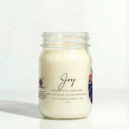 Candle jar labeled 'Joy' with a mini floral design on a clear background