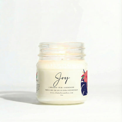 Candle jar labeled 'Joy' with a mini floral design on a clear background