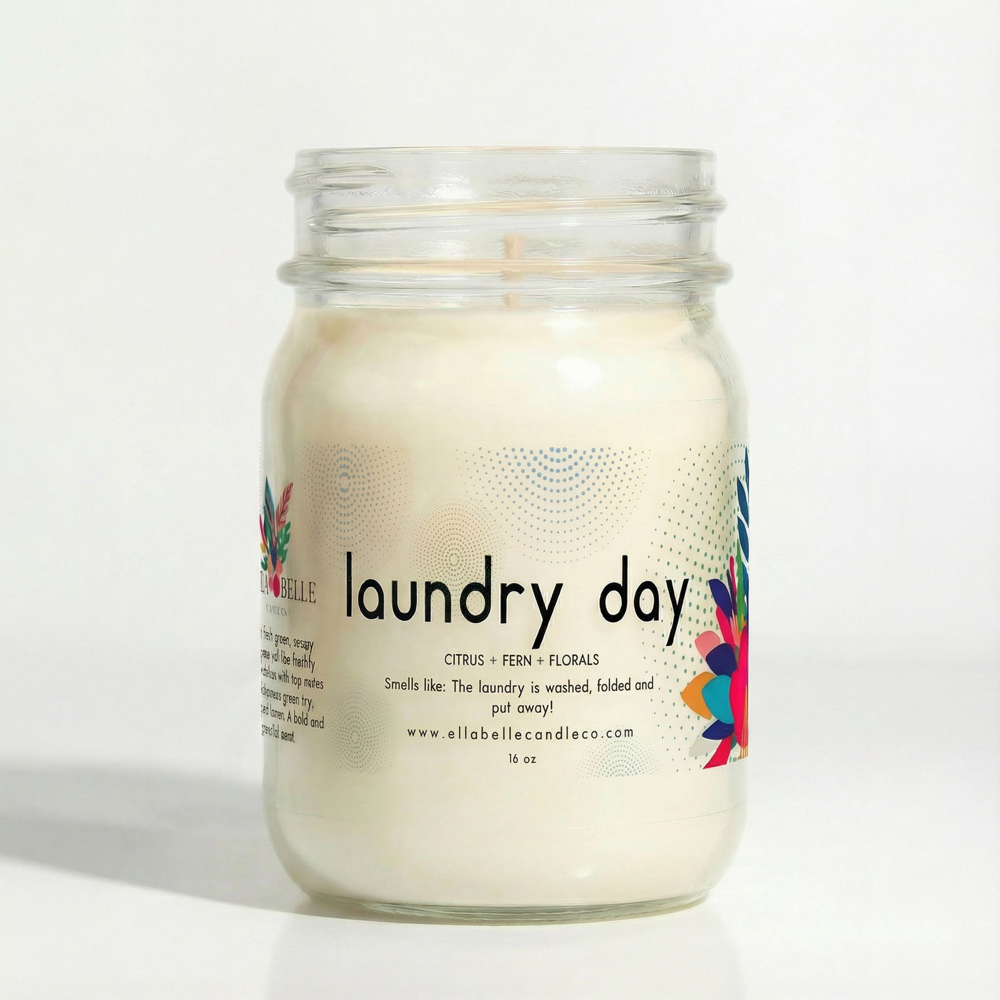 16 oz Glass candle jar labeled 'laundry day' with colorful design on a white background.