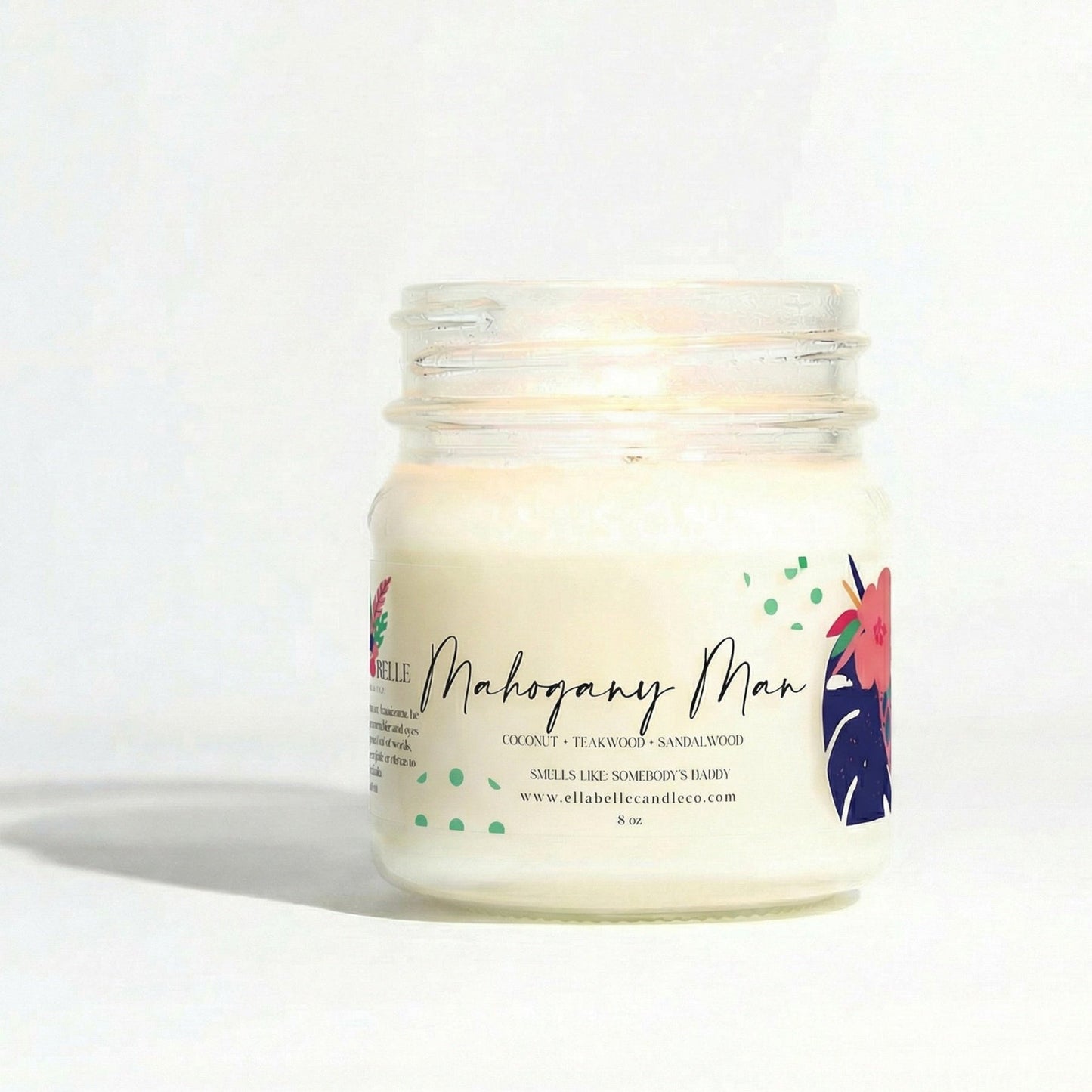 Candle in a glass jar with a colorful label  with "Mahogany Man" on a white background
