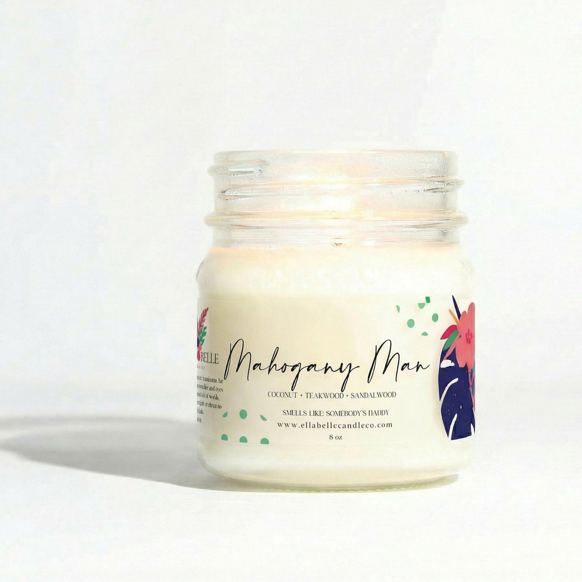Candle in a glass jar with a colorful label  with "Mahogany Man" on a white background
