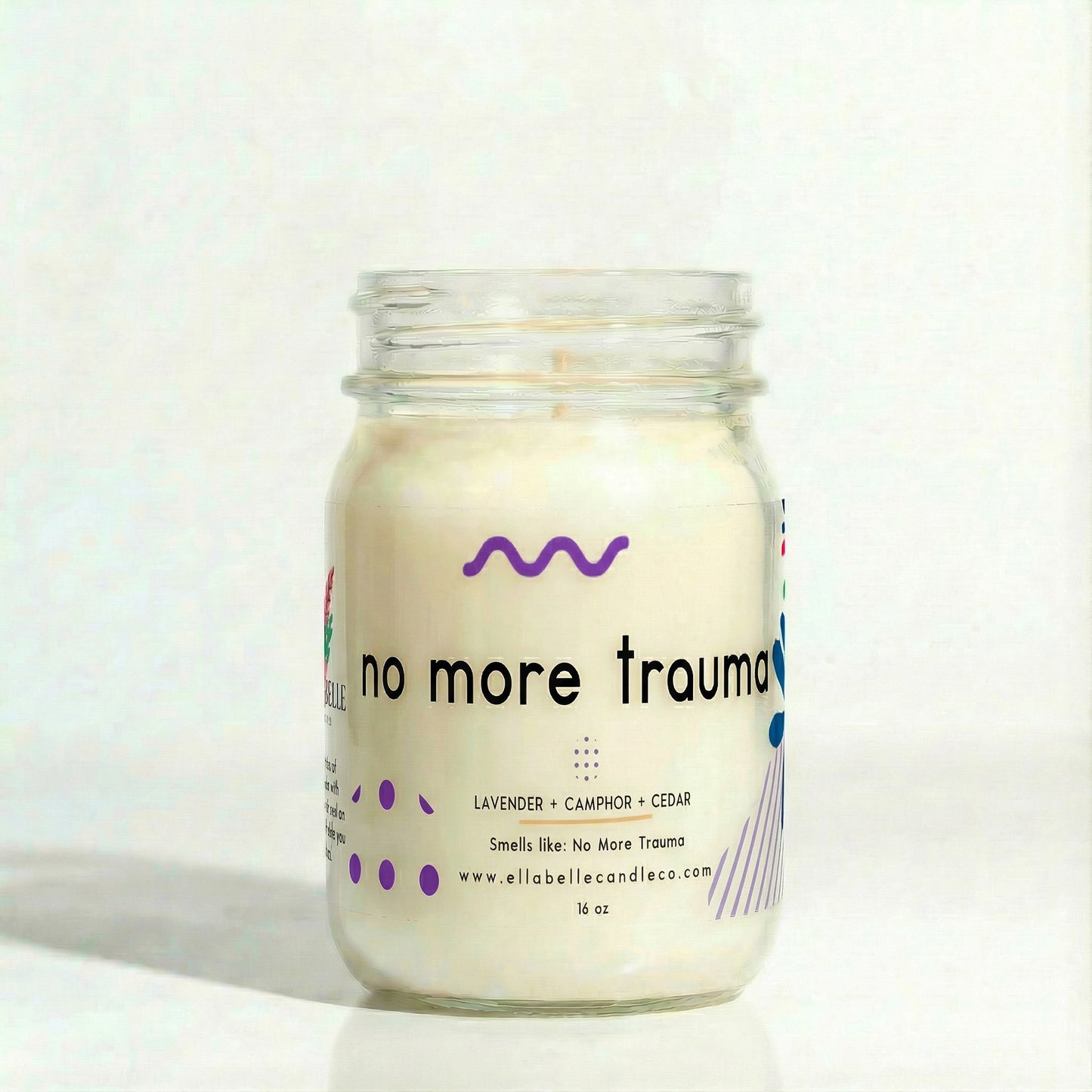 Candle jar labeled 'no more trauma' on a white background