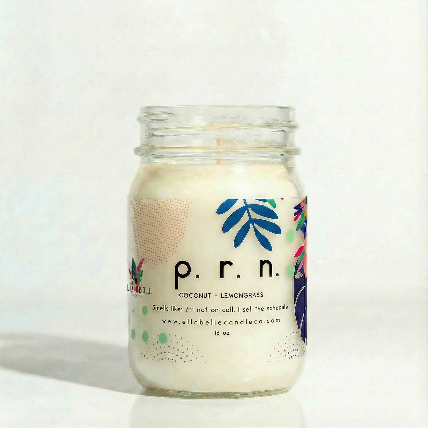 A mason jar candle with a label that reads 'P.R.N.', coconut + lemongrass with a white background