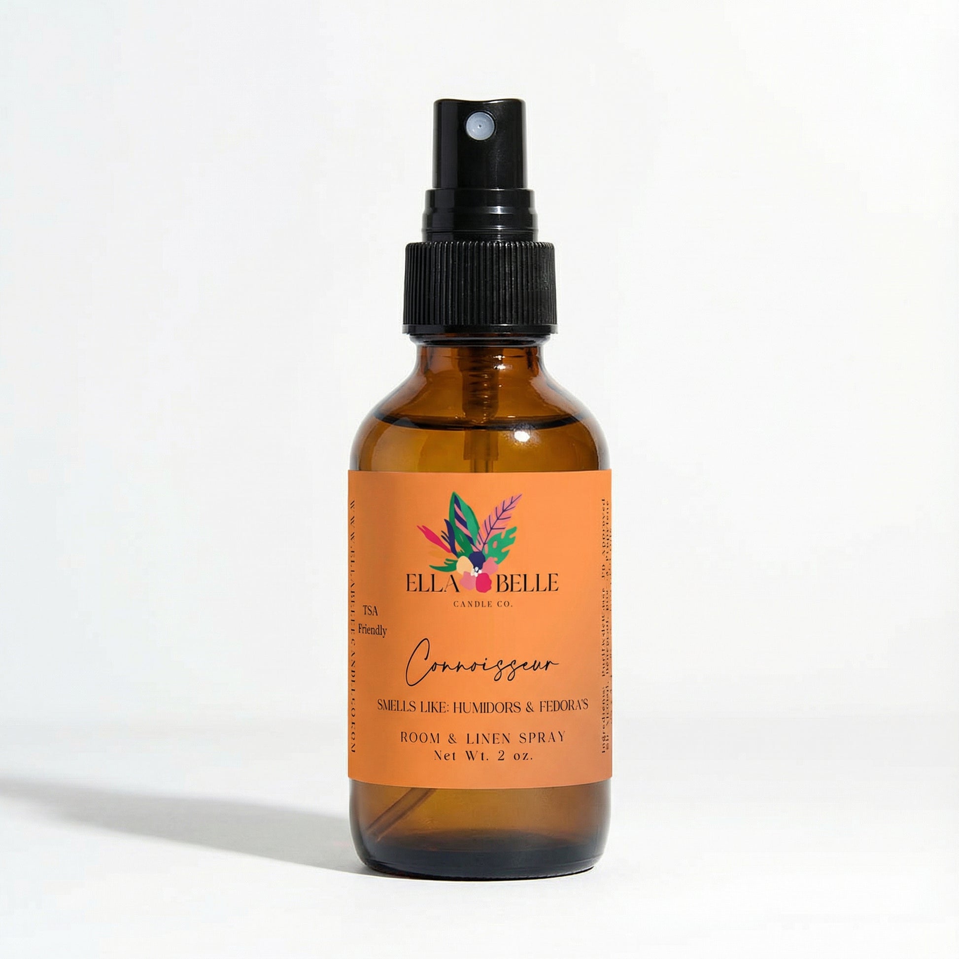 Brown glass bottle with orange label featuring 'Ella Belle Candle Co.' brand on a white background